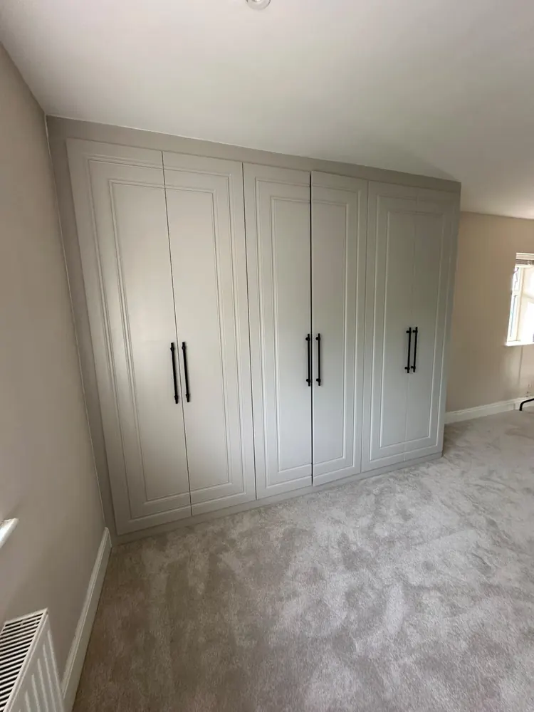 Floor-to-ceiling fitted wardrobes with panelled doors