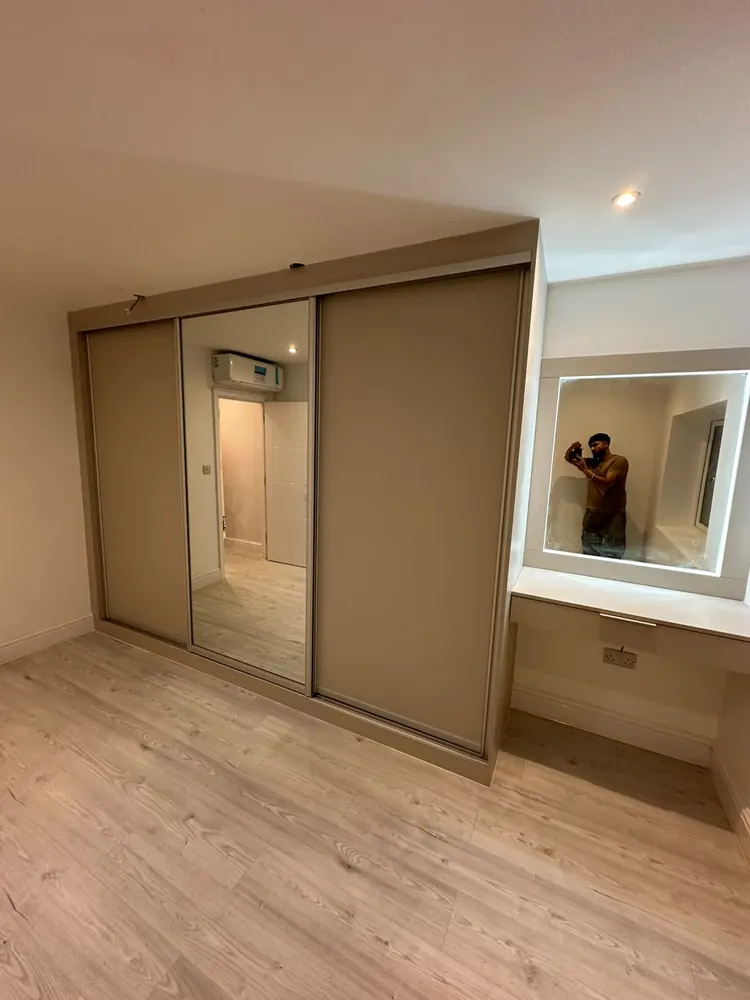 Glass sliding wardrobe doors in a modern bedroom