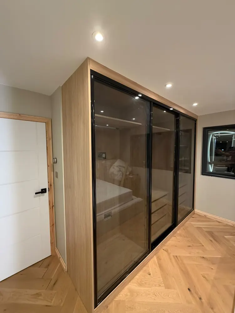 Smoked-glass sliding wardrobe with a bronze frame