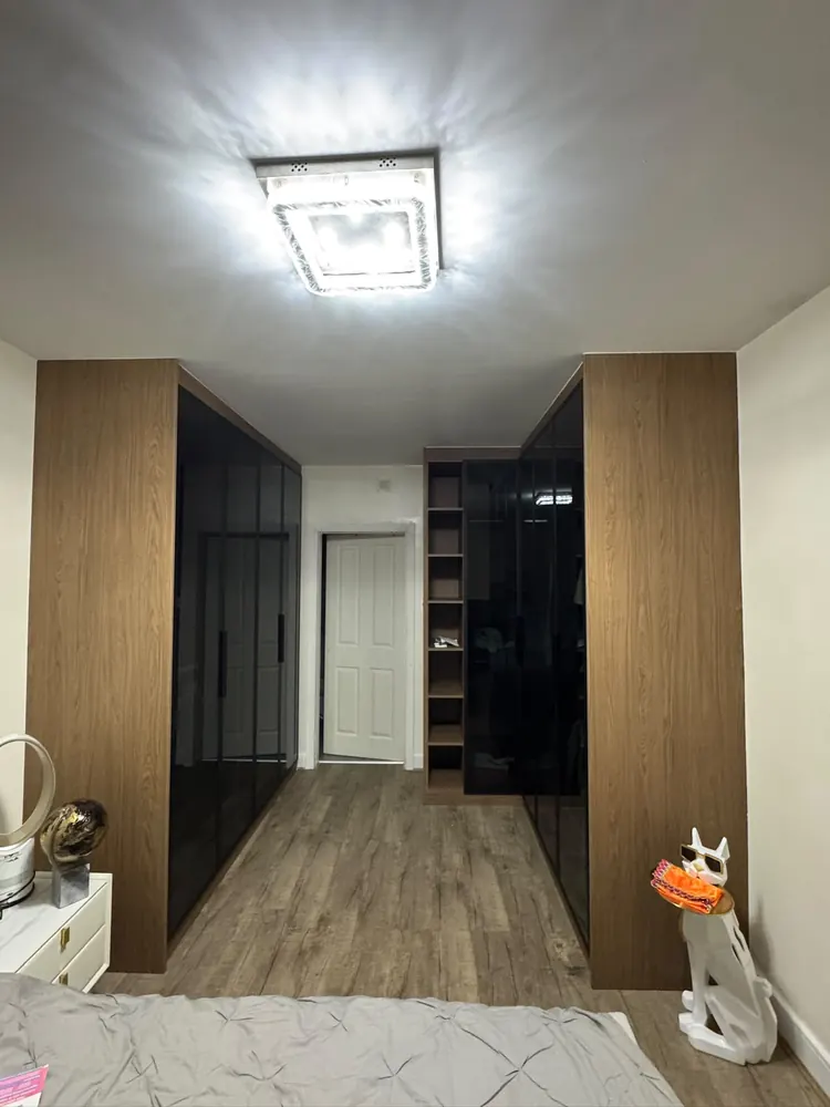 Oak-effect sliding wardrobe running along a hallway