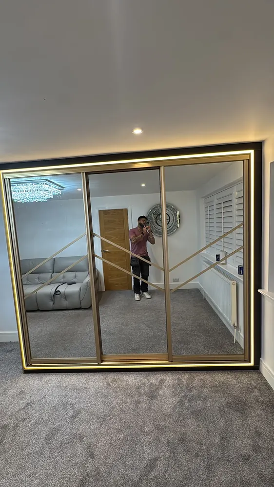 Brass-framed mirrored sliding wardrobe